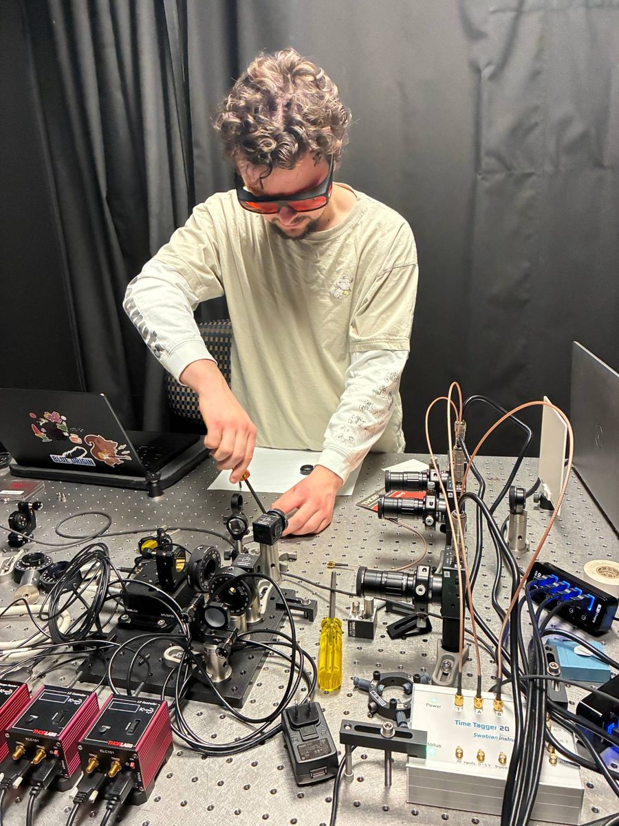 Zach aligning optics on a lab bench